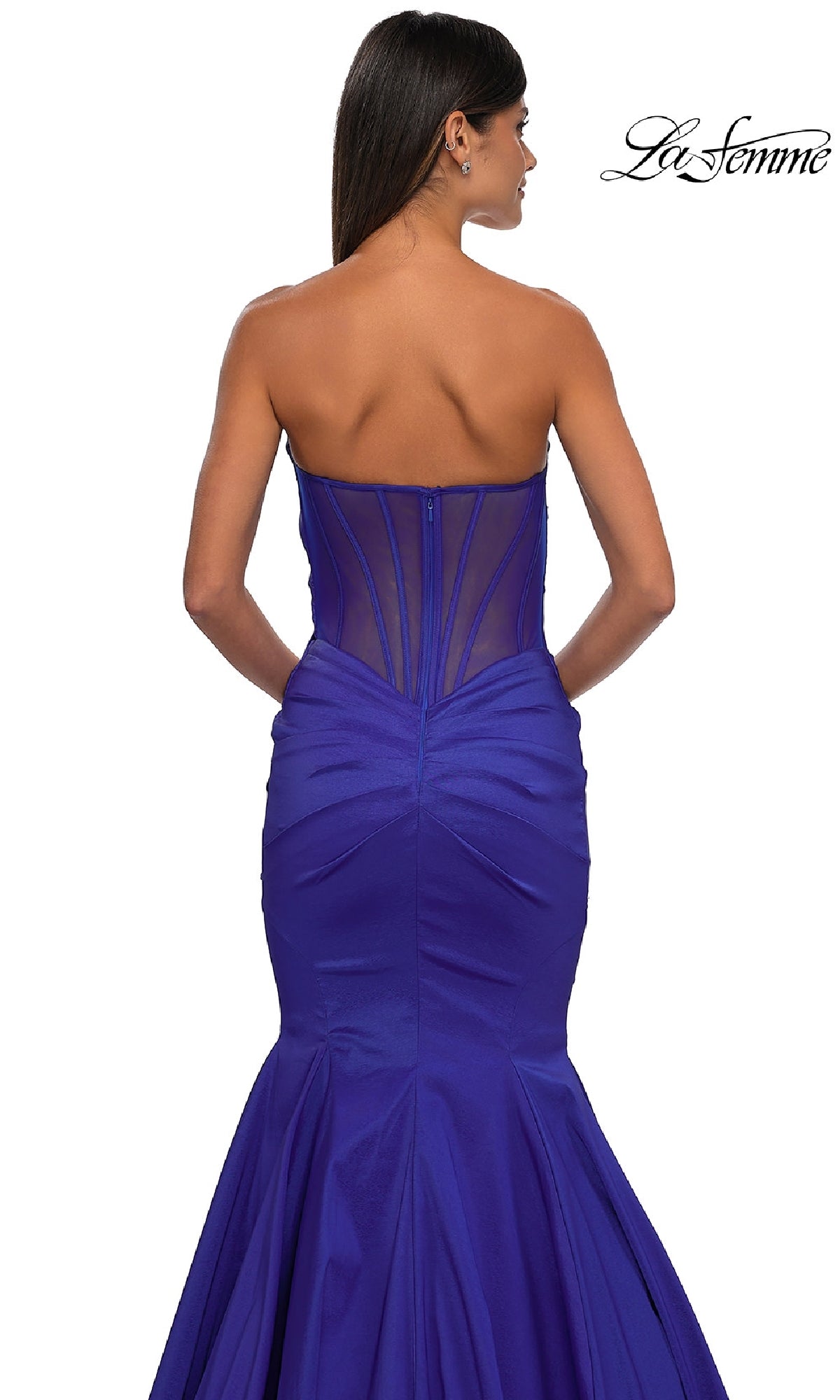 A woman models the Strapless Long Mermaid Prom Dress: La Femme 32791 in royal blue Mikado, featuring a sheer back panel and visible boning, photographed from behind against a white background.